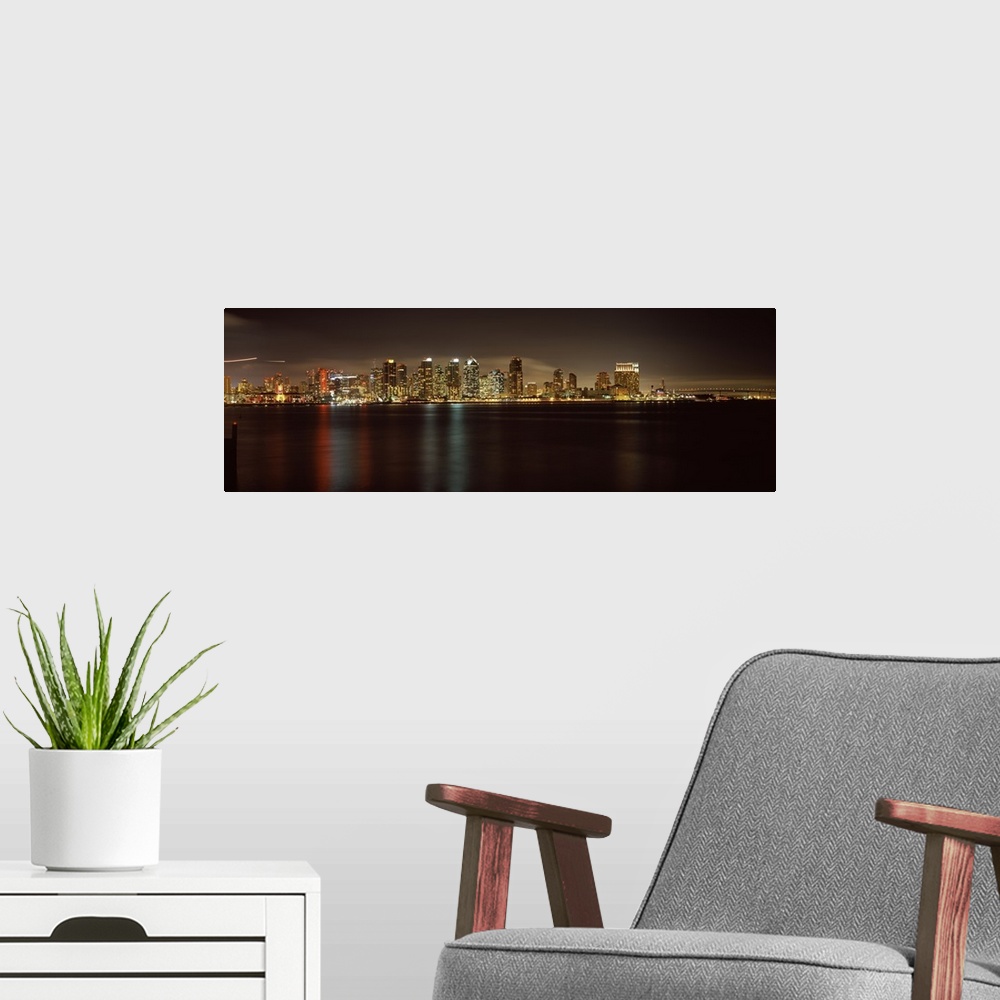 A modern room featuring Panoramic photograph of the San Diego city skyline along the edge of the bay in the evening, the ...