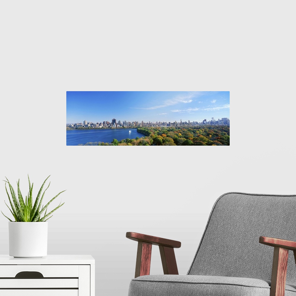 A modern room featuring NYC in the fall just as the leaves are changing.  Panoramic view of the downtown skyline across t...