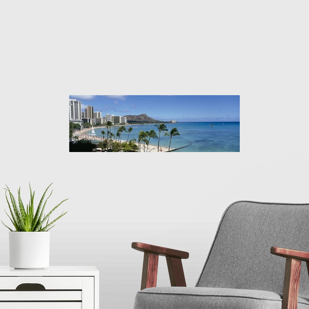 A modern room featuring A panoramic photograph of skyscrapers and beach goers lining the shore of this tropical beach at ...
