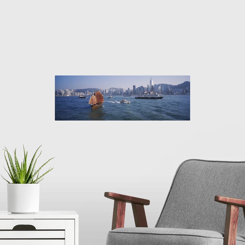 A modern room featuring Panoramic print of ships sailing in the ocean with a downtown cityscape in the distance meeting t...