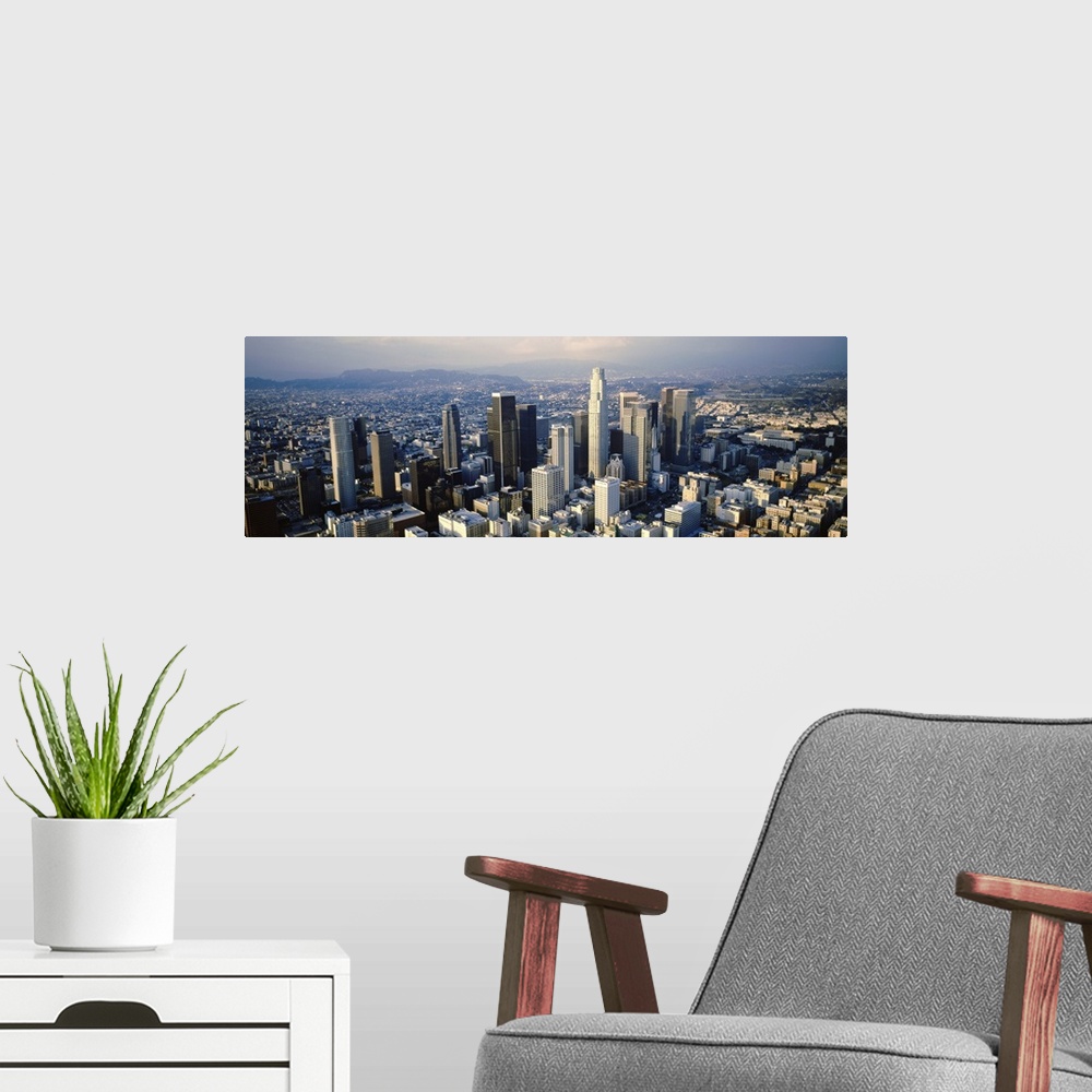 A modern room featuring Wide angle, aerial photograph on a big canvas of the city of Los Angeles beneath a slightly hazy ...