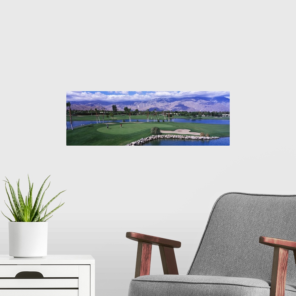A modern room featuring This panoramic photograph shows the immaculate oasis with mountains and clouds in the distance.