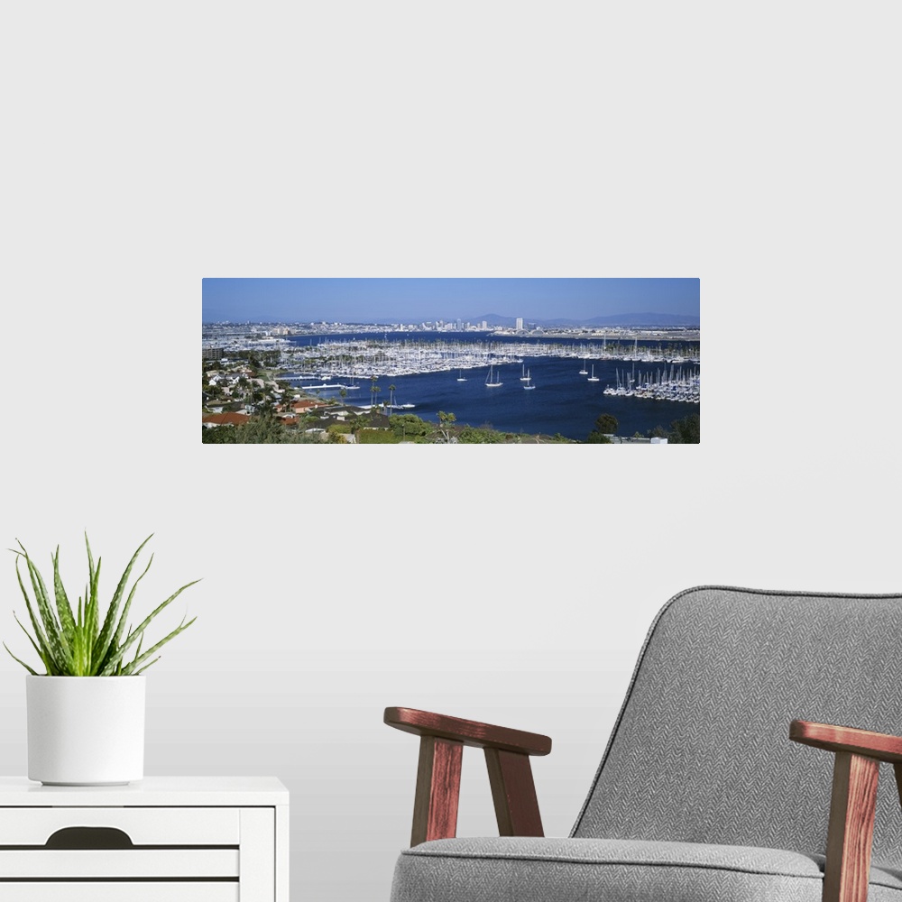 A modern room featuring A panoramic aerial view of the boats in the water of San Diego harbor.