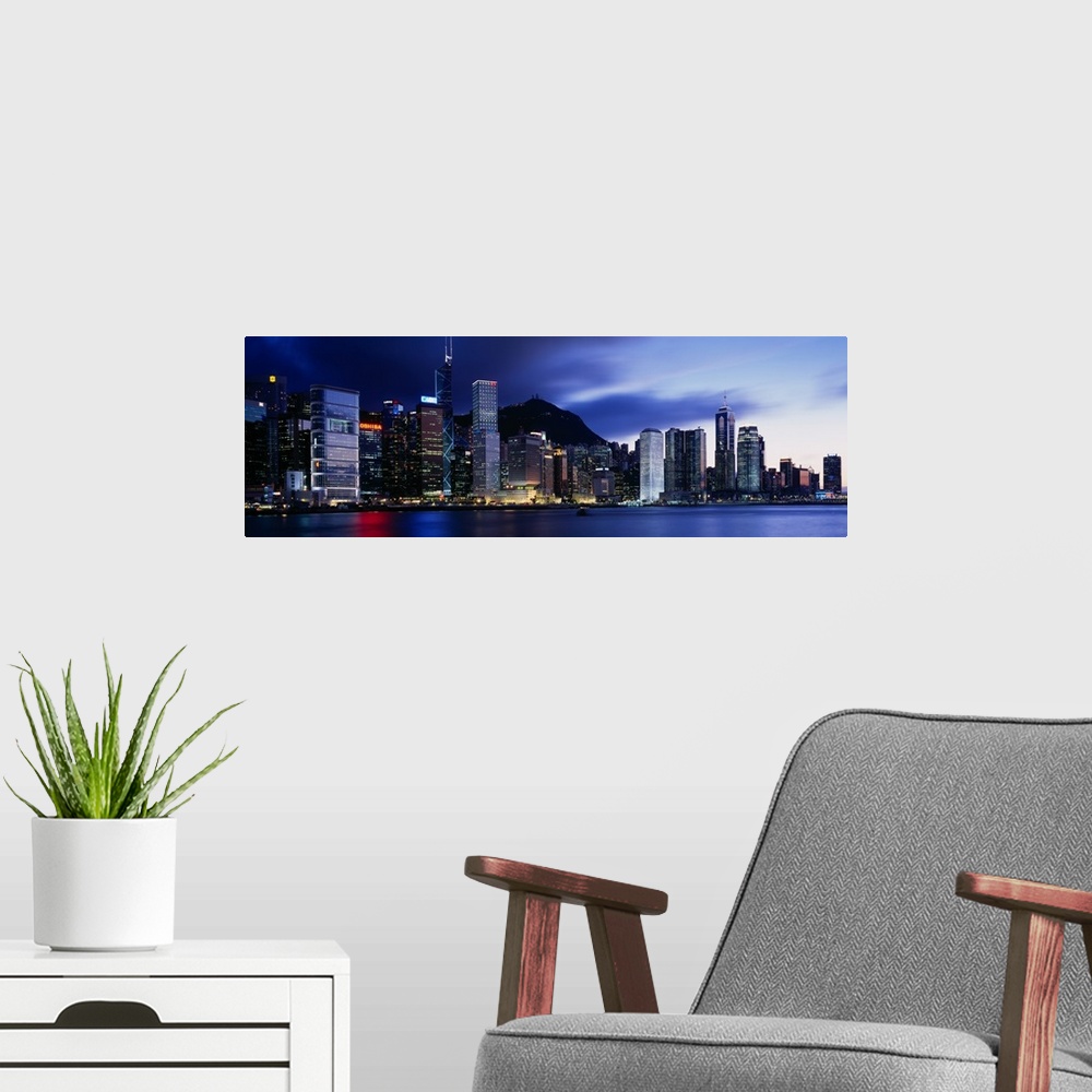 A modern room featuring Panoramic photograph displays the bright skyline of a famous city reflecting over a portion of Vi...