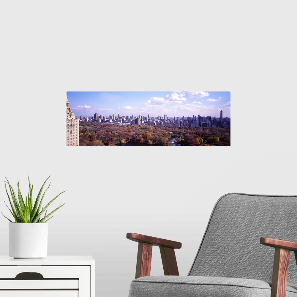 A modern room featuring View from a skyscraper of the forests in Central Park in autumn, surrounded by the tall city buil...