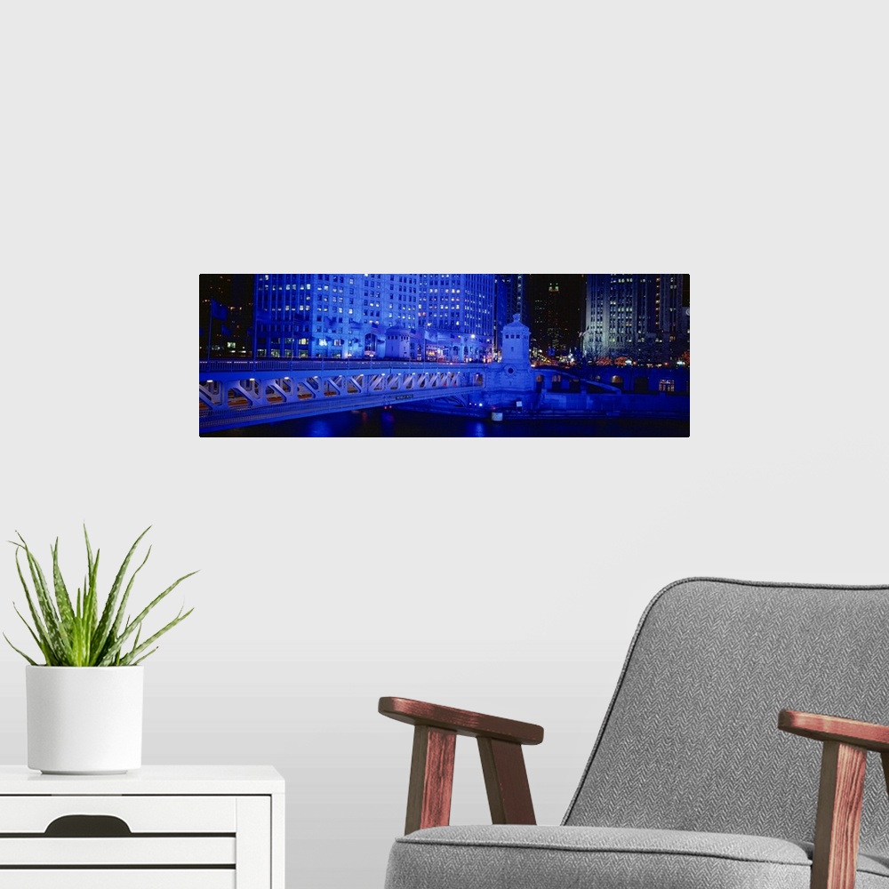 A modern room featuring Panoramic view of the Michigan Avenue Bridge during the night. The buildings in the background an...