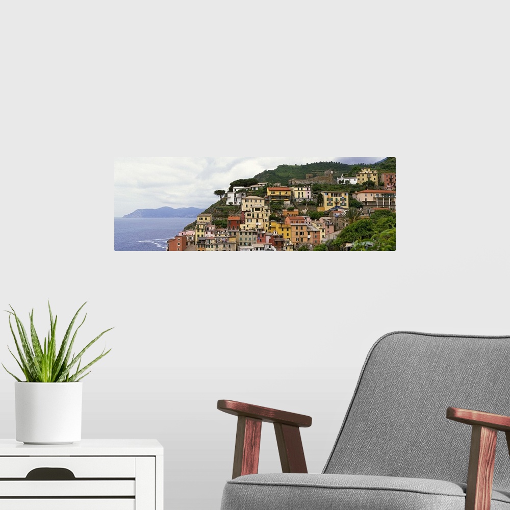 A modern room featuring This panoramic landscape photograph of homes built into the hillside overlooking the sea.