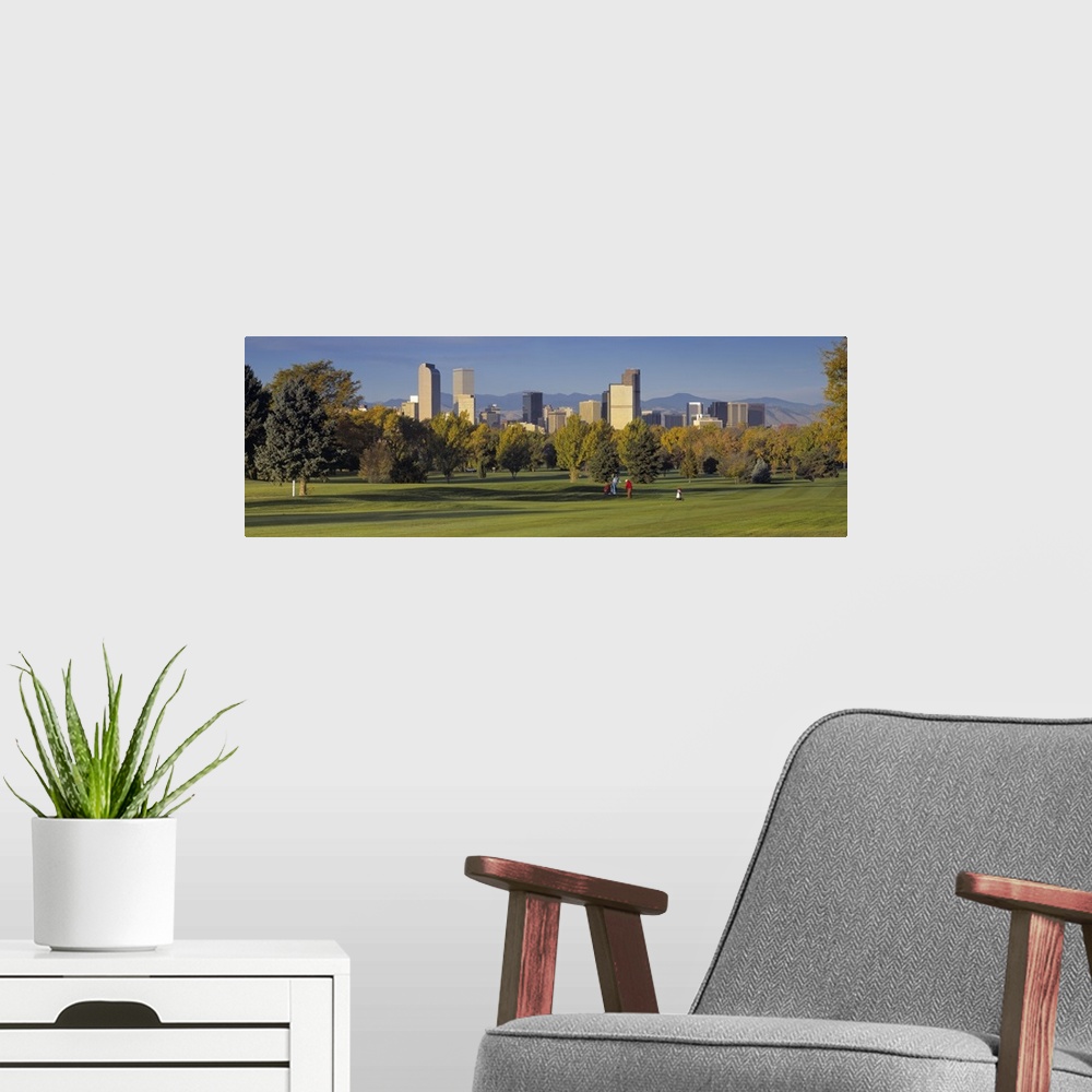 A modern room featuring Big, panoramic photograph on the green of a golf course in Colorado, full of trees, the buildings...