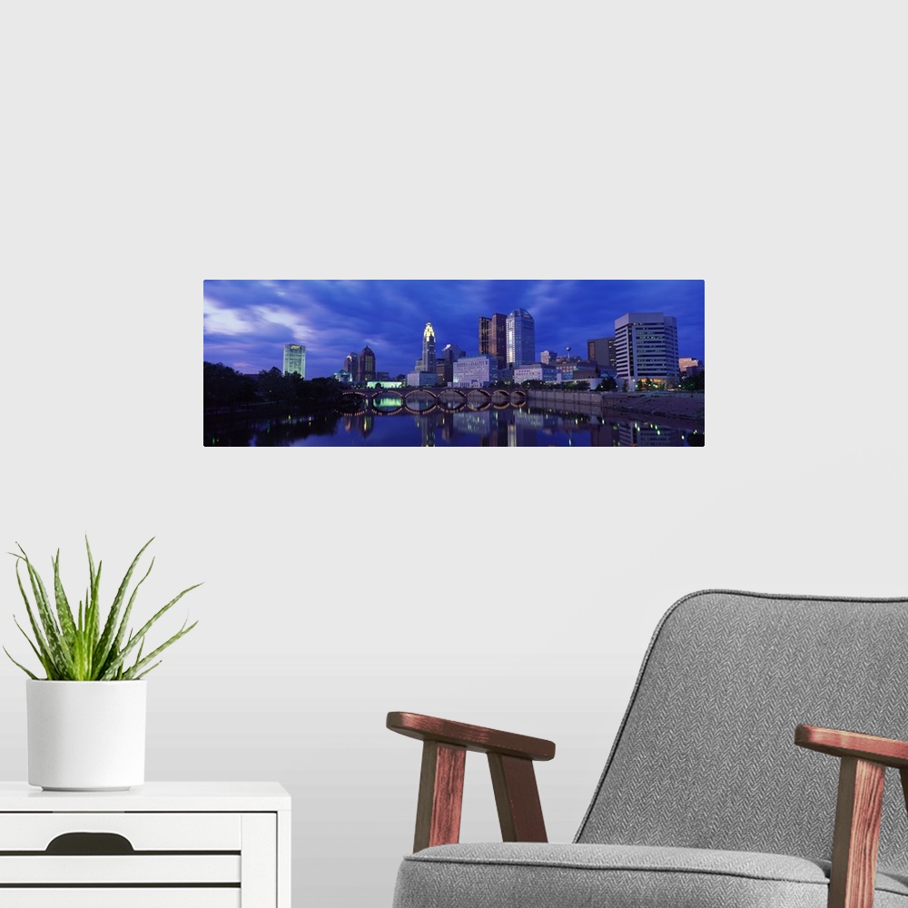 A modern room featuring Panoramic photo of downtown Columbus, Ohio with the tall buildings and lit  up bridge reflecting ...