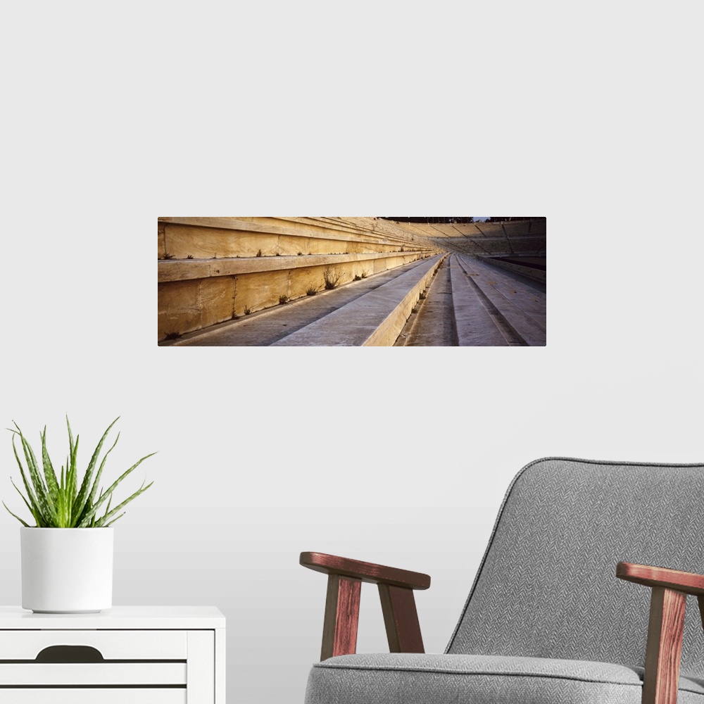 A modern room featuring Panoramic photograph of wooden seats in ancient coliseum.