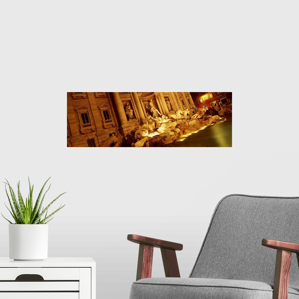 A modern room featuring Panoramic canvas photo of Roman statues that are bathed in light at night.