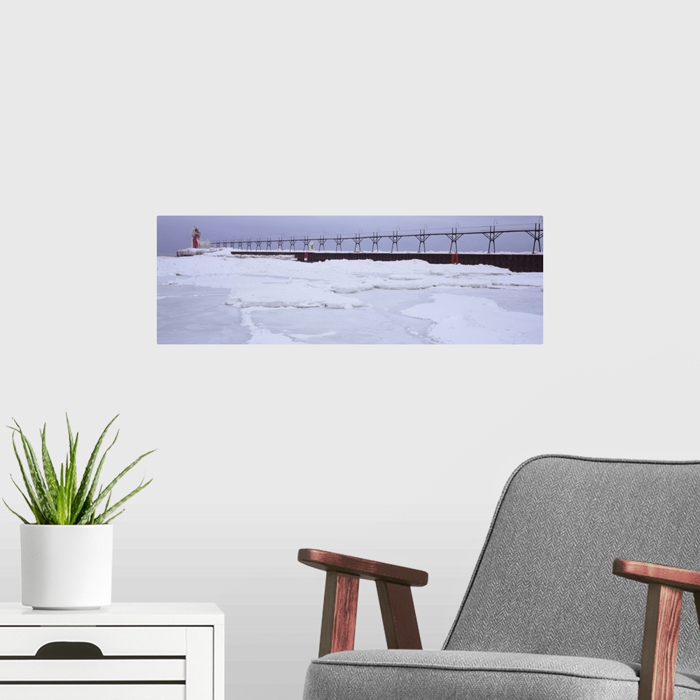 A modern room featuring Panoramic photograph of pier stretching into ice covered river leading to a tower with a guiding ...