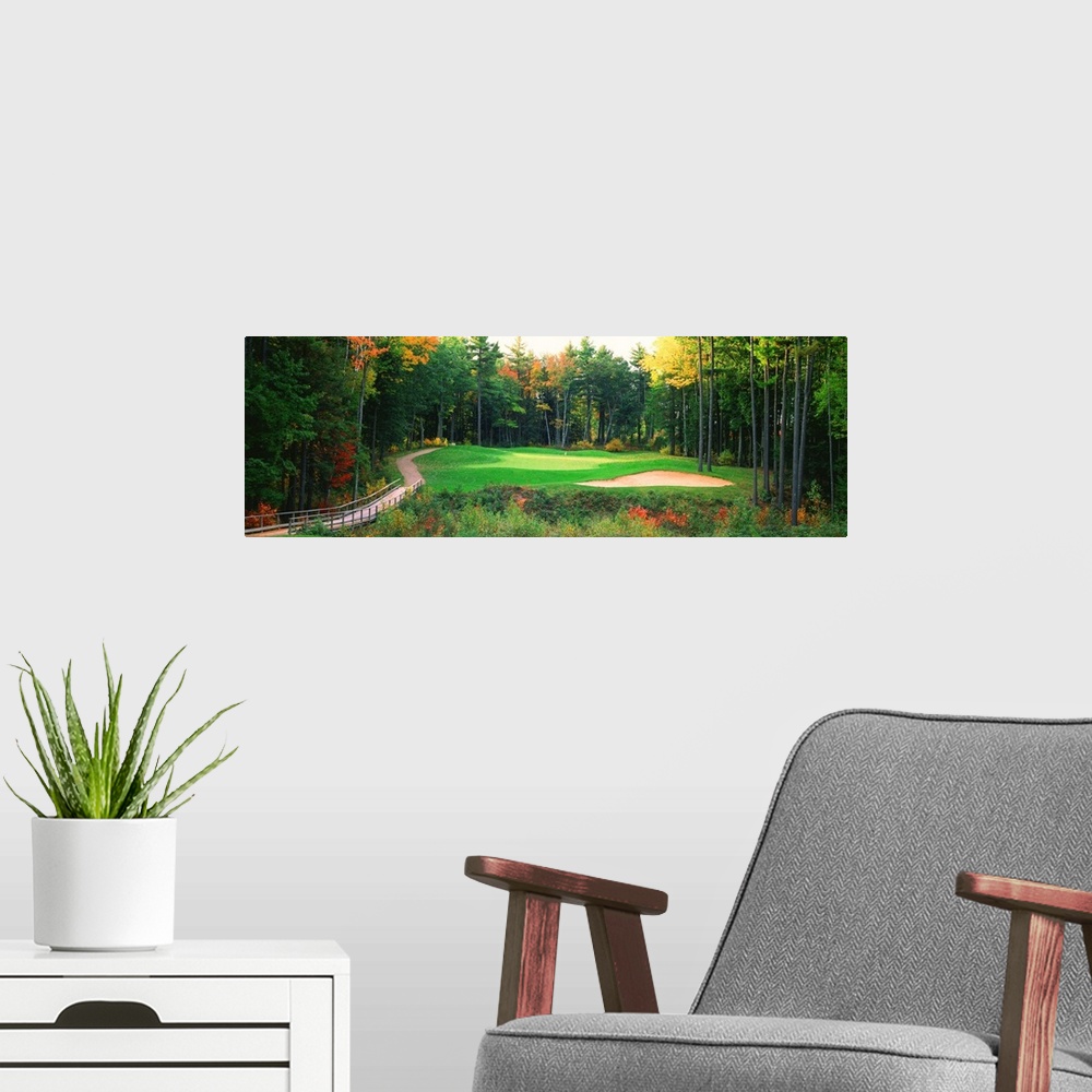 A modern room featuring Panoramic photo of a golf green in the Northern United States. A wooden bridge leads to the hole ...