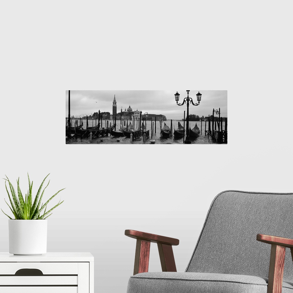 A modern room featuring Wide angle photograph of a line of gondolas parked near the shore, the Church Of San Giorgio Magg...