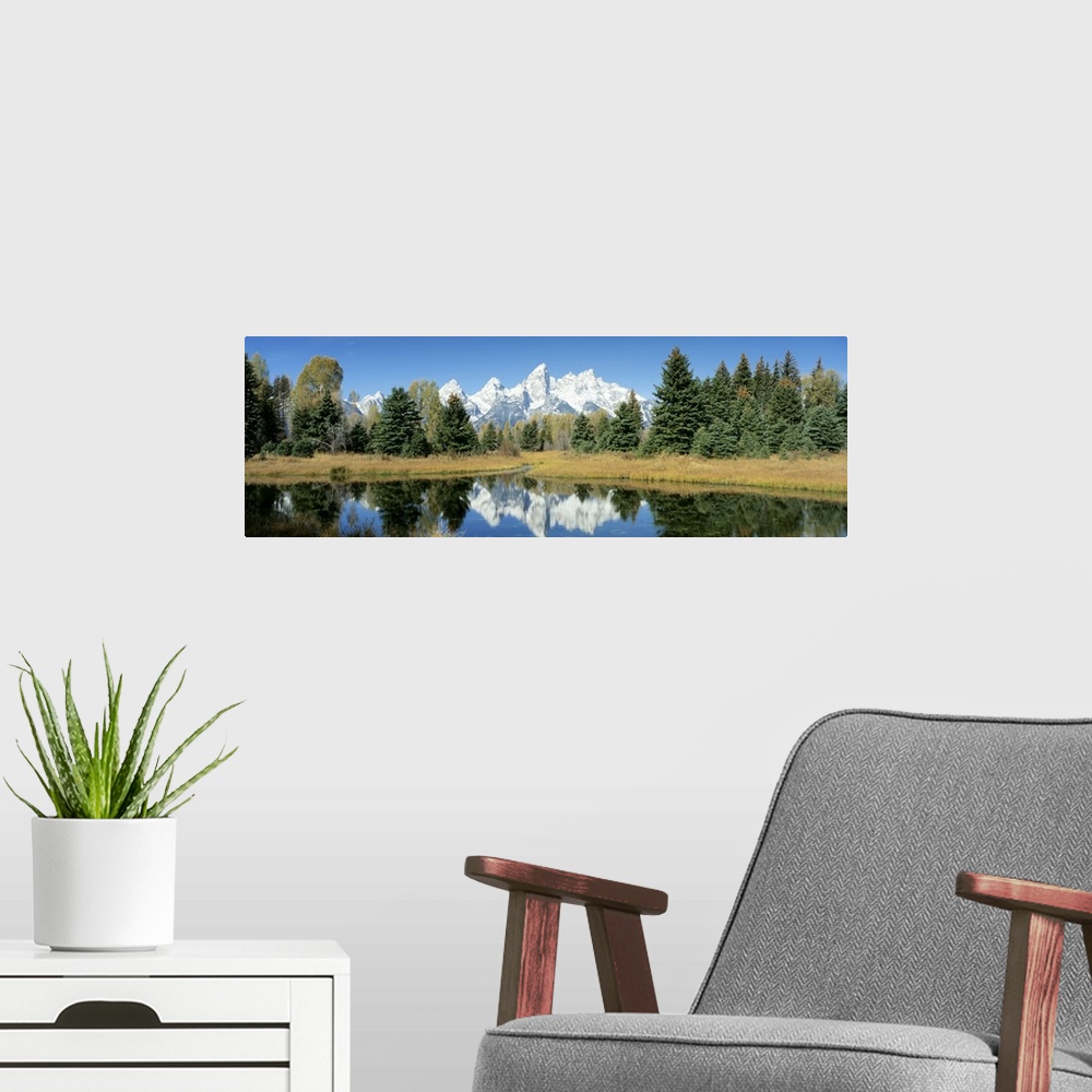 A modern room featuring This panoramic shot is perfect for the home or office of a national park with a body of water in ...