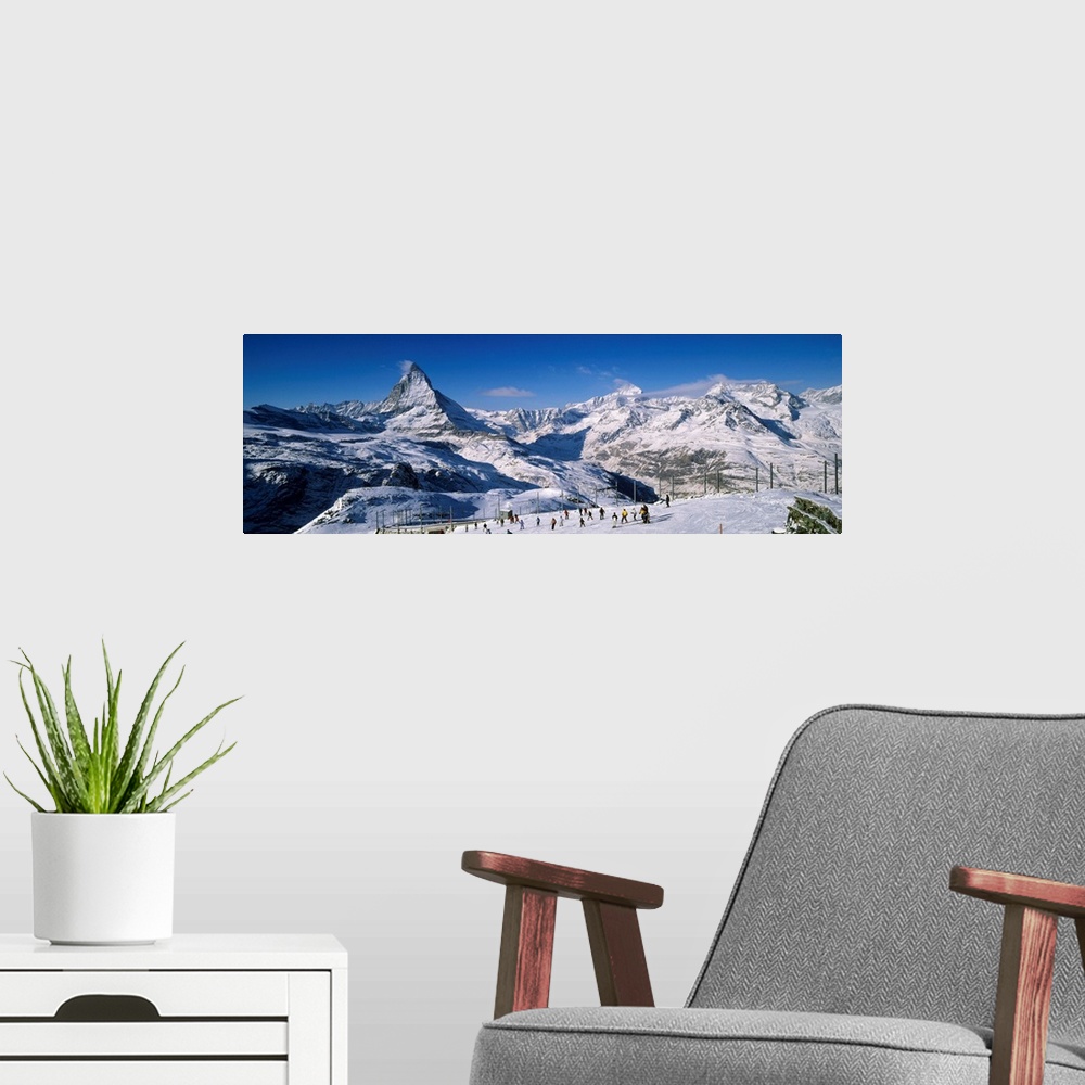 A modern room featuring Group of people skiing near a snow covered mountain, Matterhorn, Switzerland