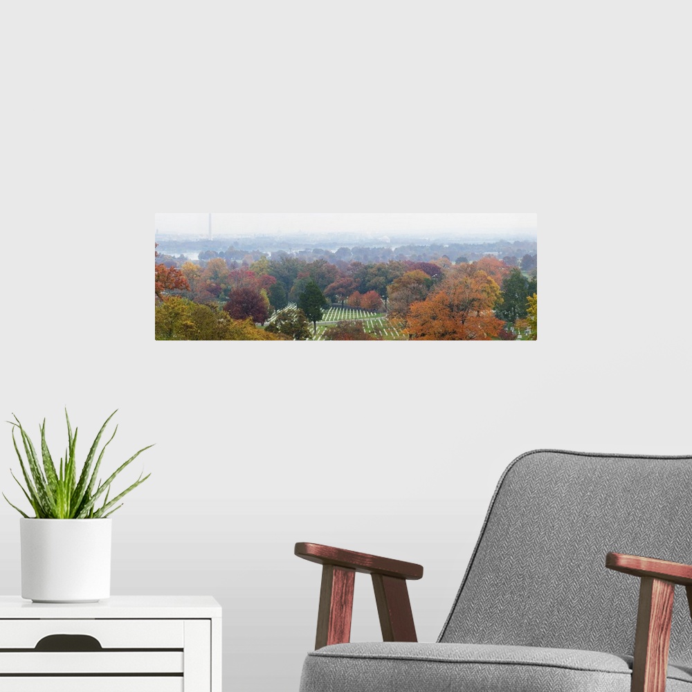 A modern room featuring An ariel photograph of Arlington National Cemetery surrounded by autumn colored trees and a view ...
