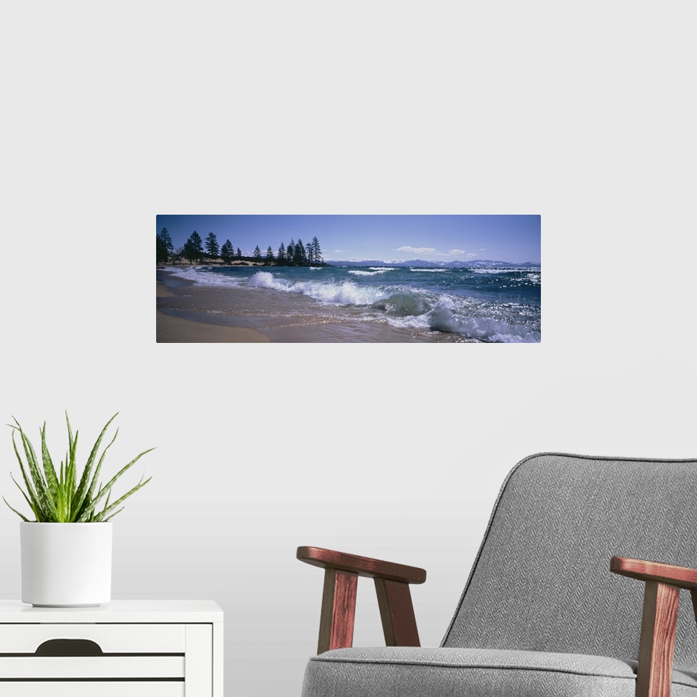 A modern room featuring Panoramic photograph shows the waves of a large body of water in Nevada crashing against a sandy ...