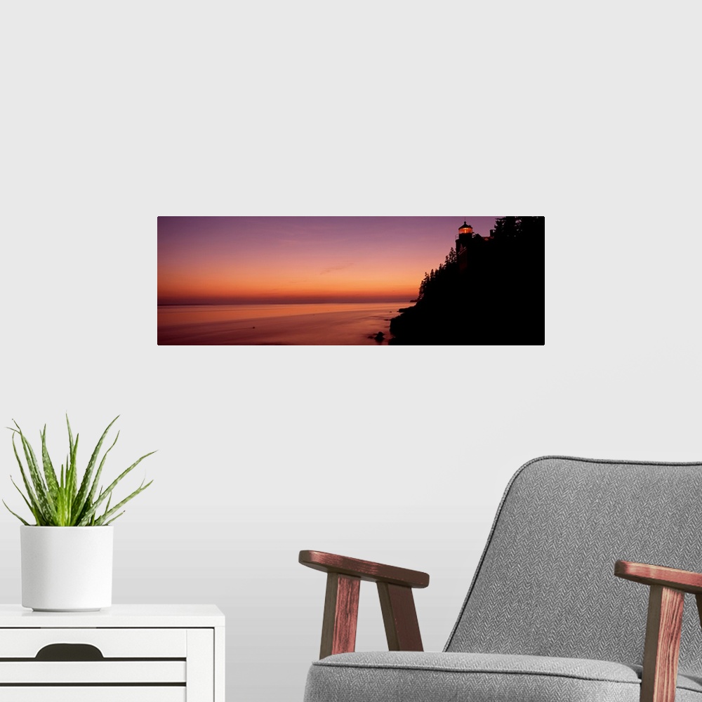 A modern room featuring Panoramic photograph taken during a sunset with a lighthouse shown on the right side of the pictu...