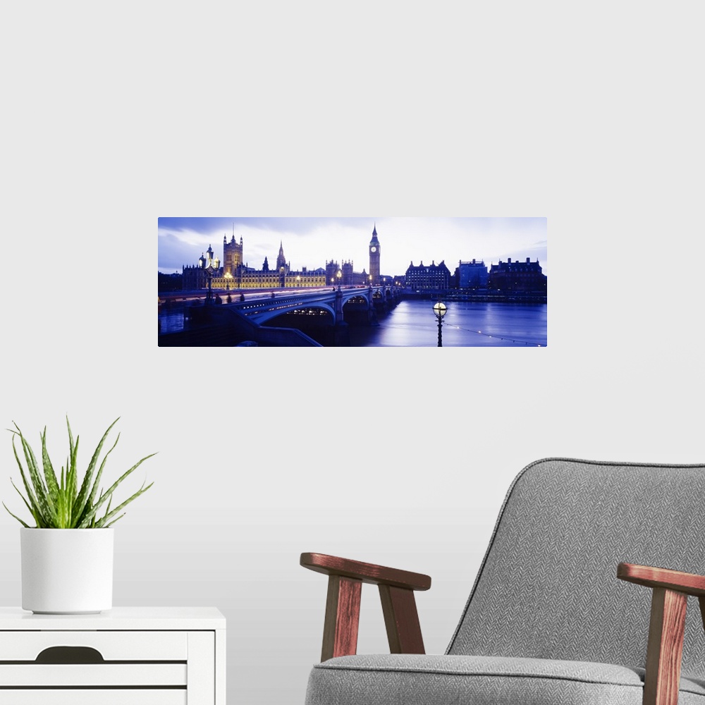 A modern room featuring London skyline with the Houses of Parliament and Big Ben. Panoramic image taken at dusk with ligh...