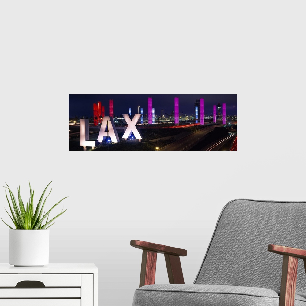 A modern room featuring Large panoramic photograph of the Los Angeles International Airport with large LAX letters by a h...