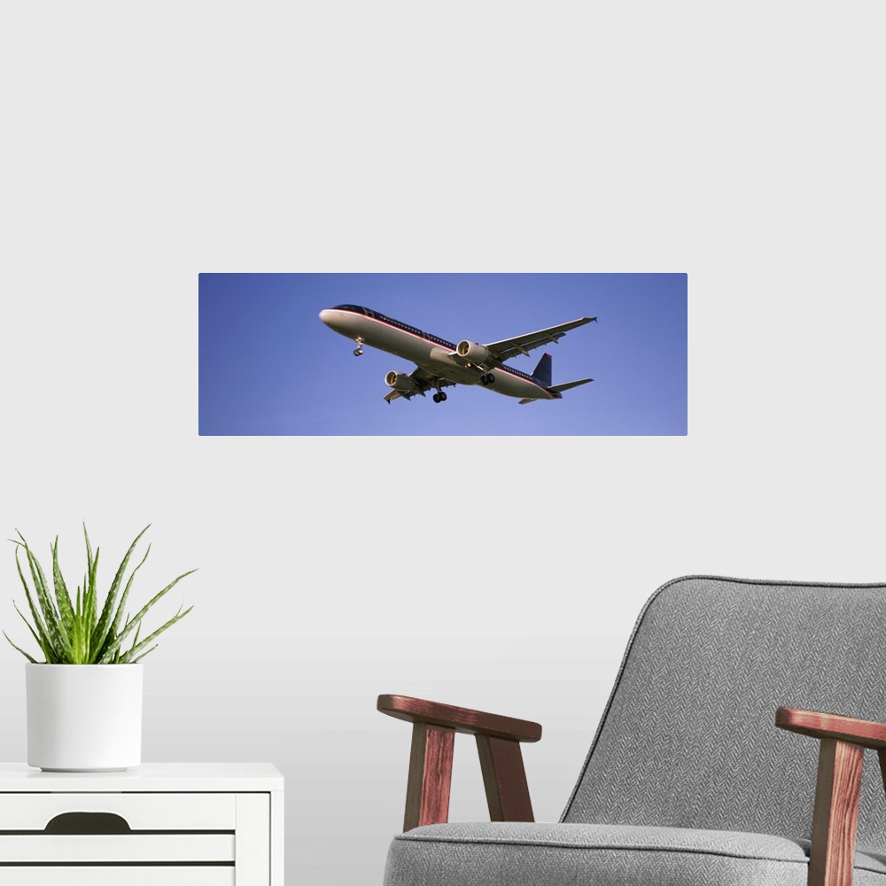 A modern room featuring Low angle view of an airplane flying