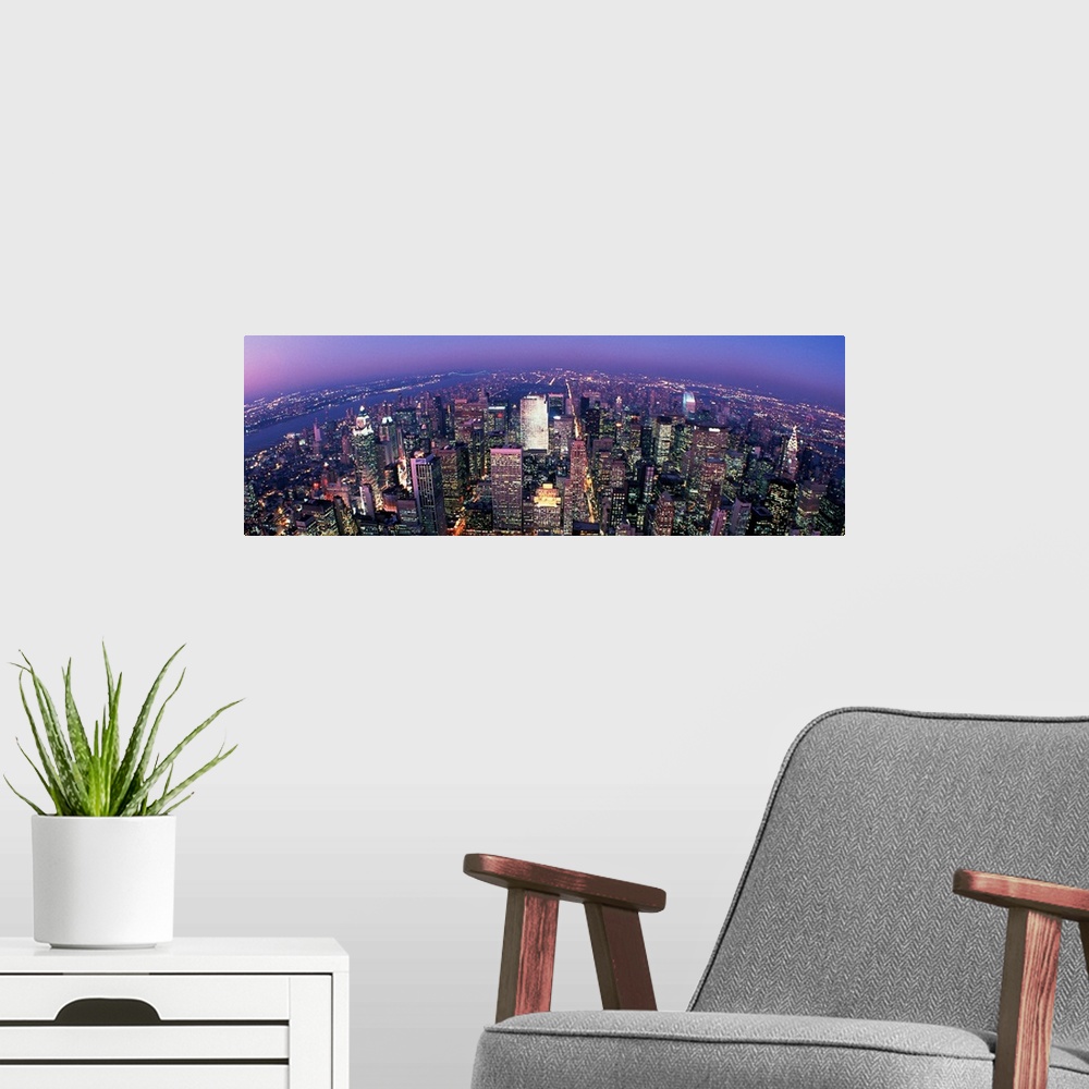 A modern room featuring Wall docor of a sky view of New York City's illuminated streets and buildings that reach towards ...
