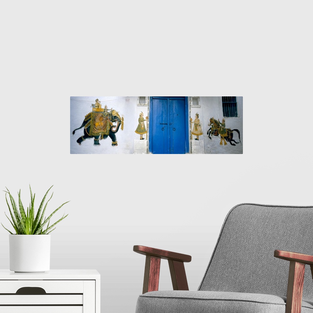 A modern room featuring Panoramic photograph taken of a mural painted on either side of bright blue doors. The mural cons...