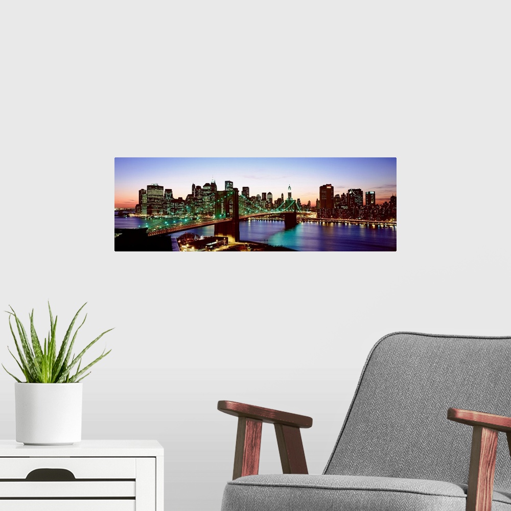 A modern room featuring This panoramic photograph shows the entire Brooklyn Bridge and the bottom of the island of Manhat...