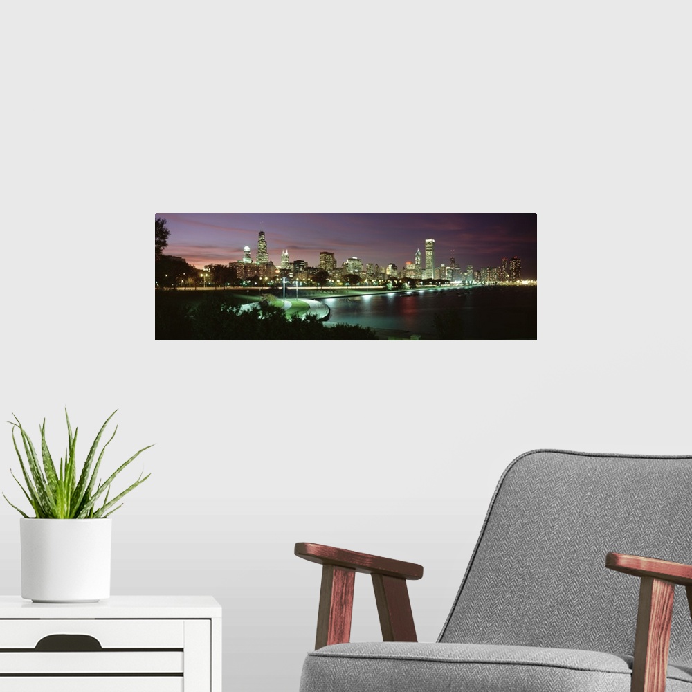A modern room featuring Panoramic photograph at nighttime shows the illuminated skyscrapers and buildings that fill the s...