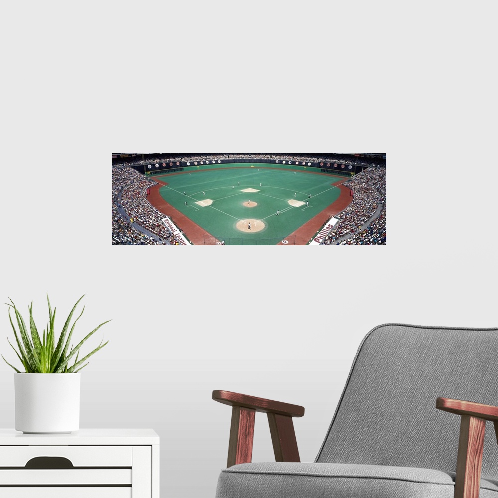A modern room featuring Wide angle photograph of Veterans Stadium in Pennsylvania.  The stands are packed with fans durin...