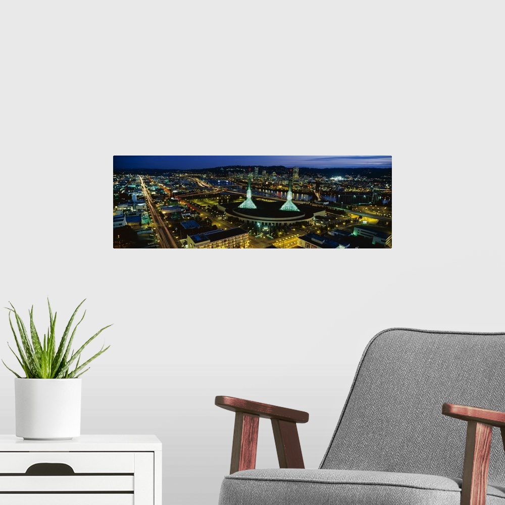 A modern room featuring Oregon's most populous city lit up in the evening by the glowing lights of office buildings and t...