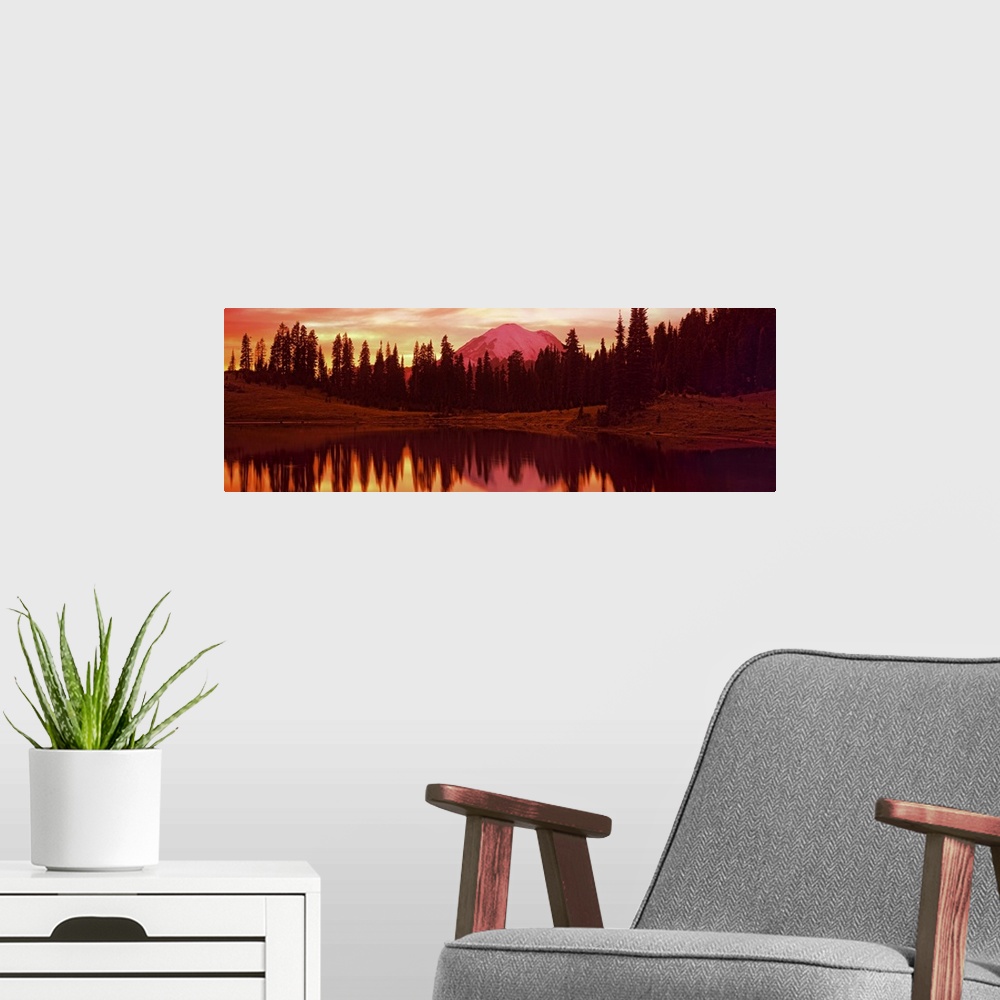 A modern room featuring Panoramic image of Mount Rainier reflected with trees in a lake printed on canvas.