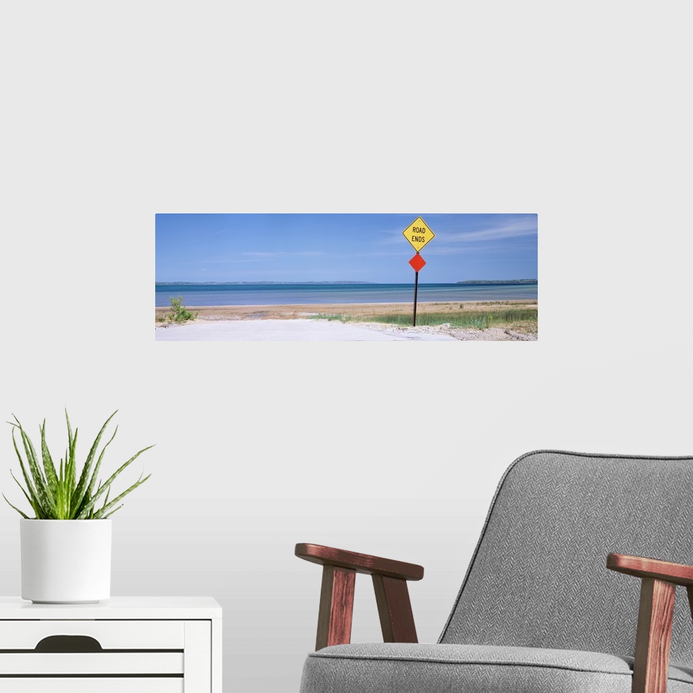 A modern room featuring Photograph taken at the end of a road which looks out onto a beach and the ocean.