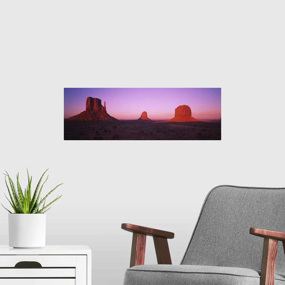 A modern room featuring Rock formations on an arid landscape at dusk, Monument Valley, Utah