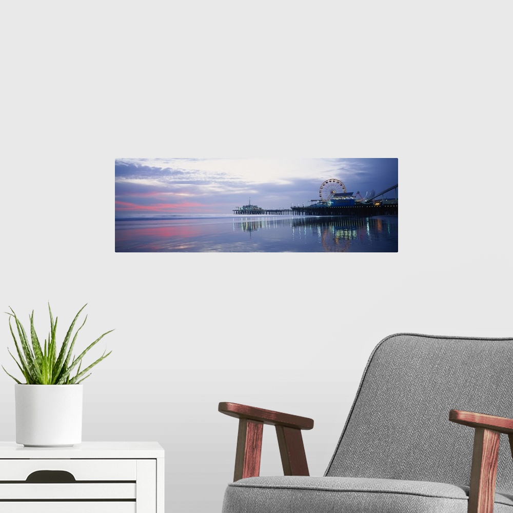 A modern room featuring A panoramic photograph taken at sunset showing the harbor, illuminated dock, Ferris wheel, and am...