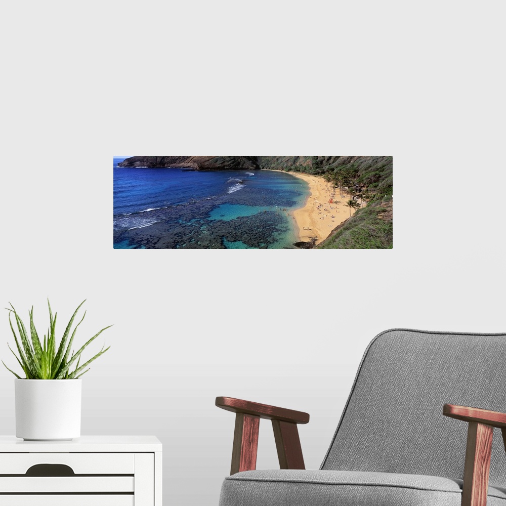 A modern room featuring Panoramic photograph of inlet with coral and beach lined with mountains.