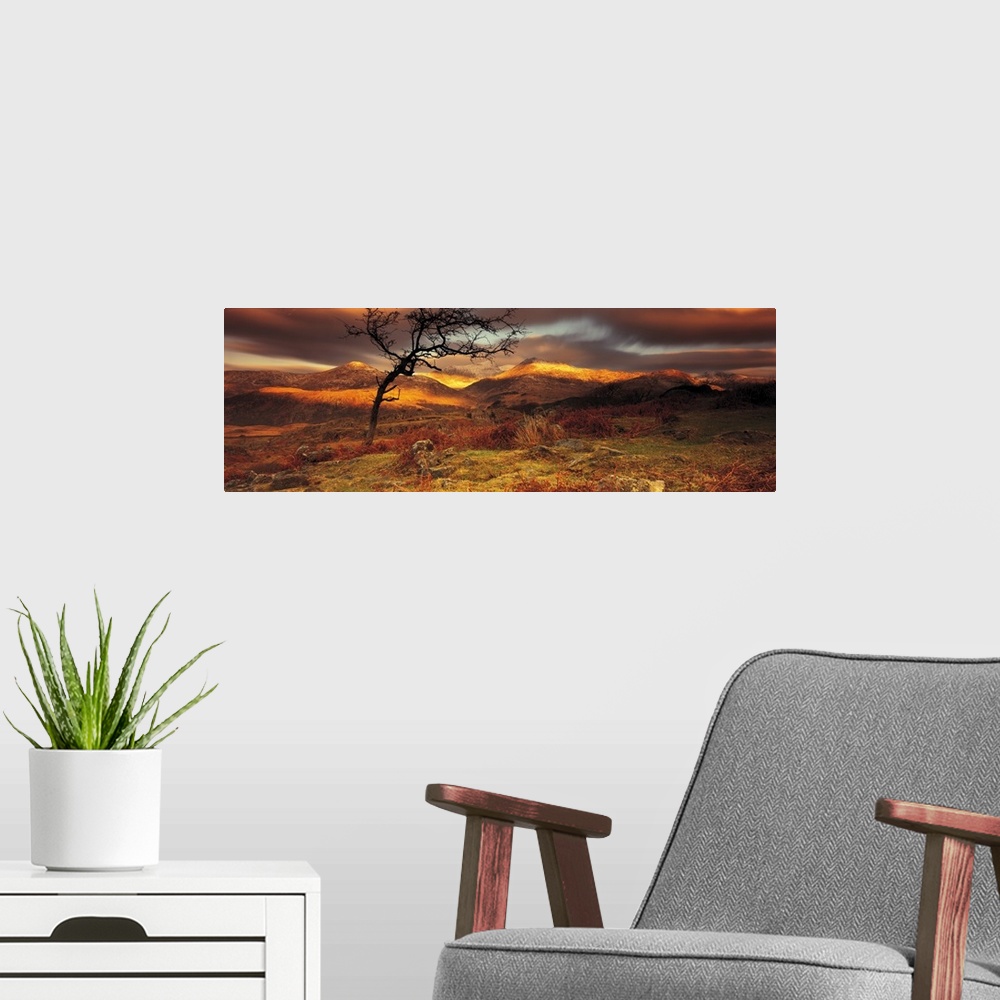 A modern room featuring Vast hills and bare land are photographed in panoramic view. Sun touches part of the hills and a ...
