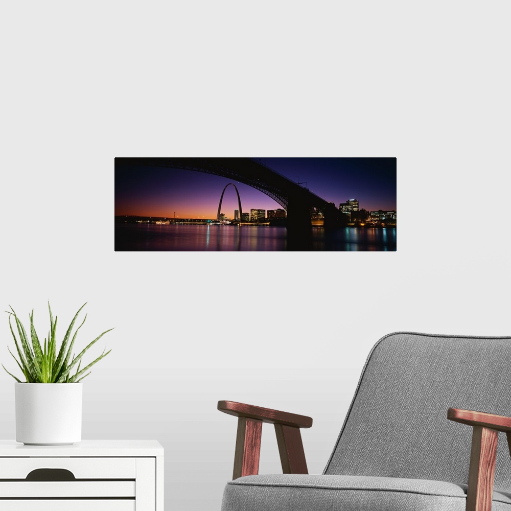 A modern room featuring A dramatic panorama of downtown St. Louis including bridges, the arch and sunset.