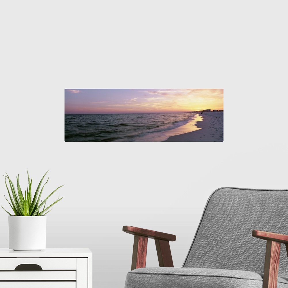 A modern room featuring Panoramic picture taken from a beach in Florida with a sun kissed sky over the ocean.