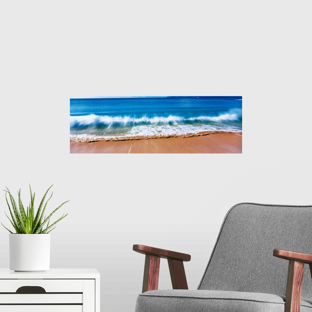A modern room featuring Giant, landscape photograph of a large wave crashing into the sands of Big Makena Beach in Maui, ...