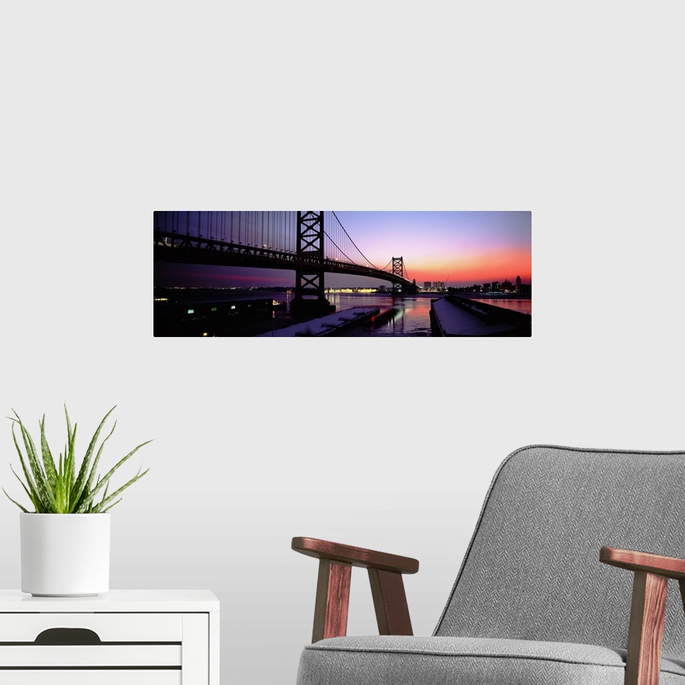 A modern room featuring Long horizontal photo print of a big bridge in Philadelphia reaching across a river at sunset.