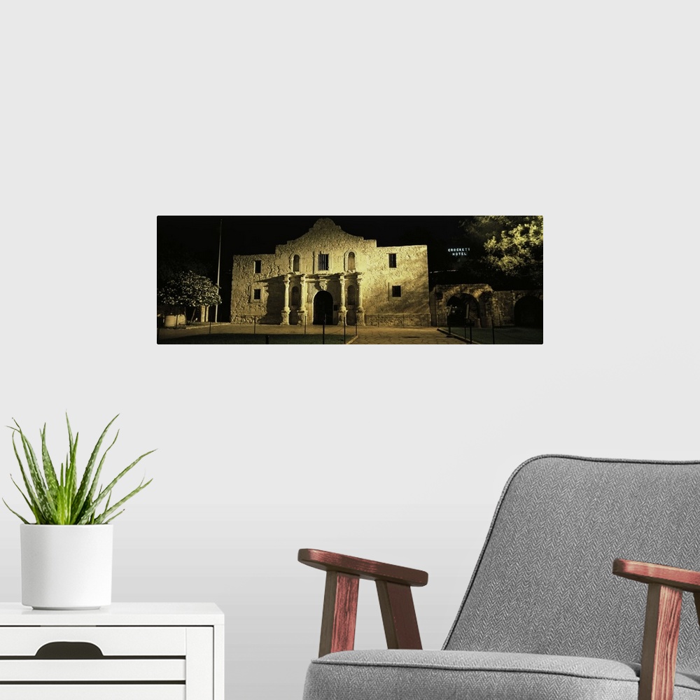 A modern room featuring Large, panoramic photograph of New Mexico's famous Alamo, shone in the light as it is surrounded ...