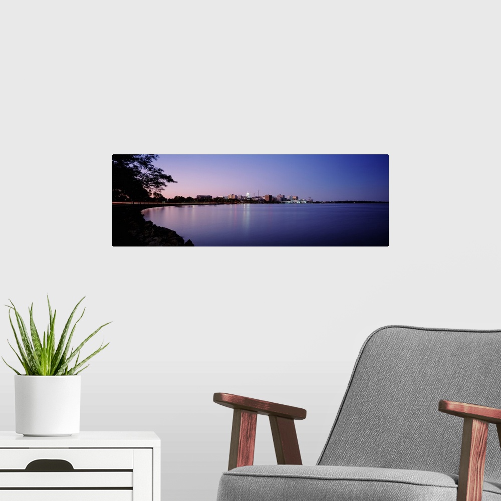A modern room featuring Panoramic photo print of buildings in Madison on the waterfront lit up at dusk.