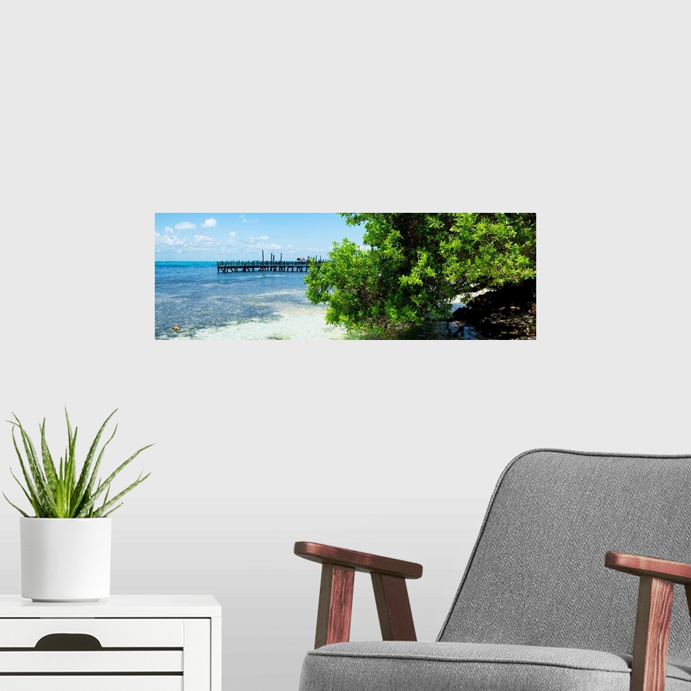 A modern room featuring Panoramic photograph of the beautiful, clear blue Caribbean coastline with a pier in the distance...