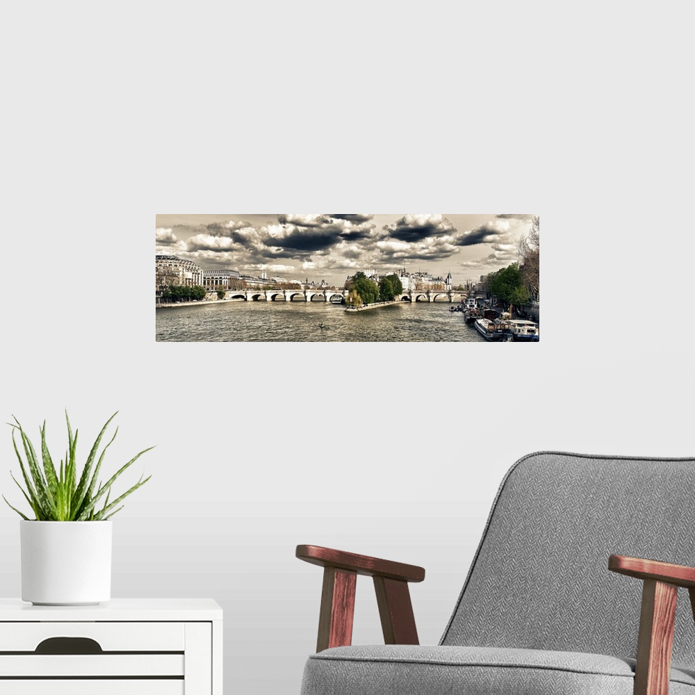 A modern room featuring Panoramic view of an arched bridge over the River Seine under dramatic clouds.