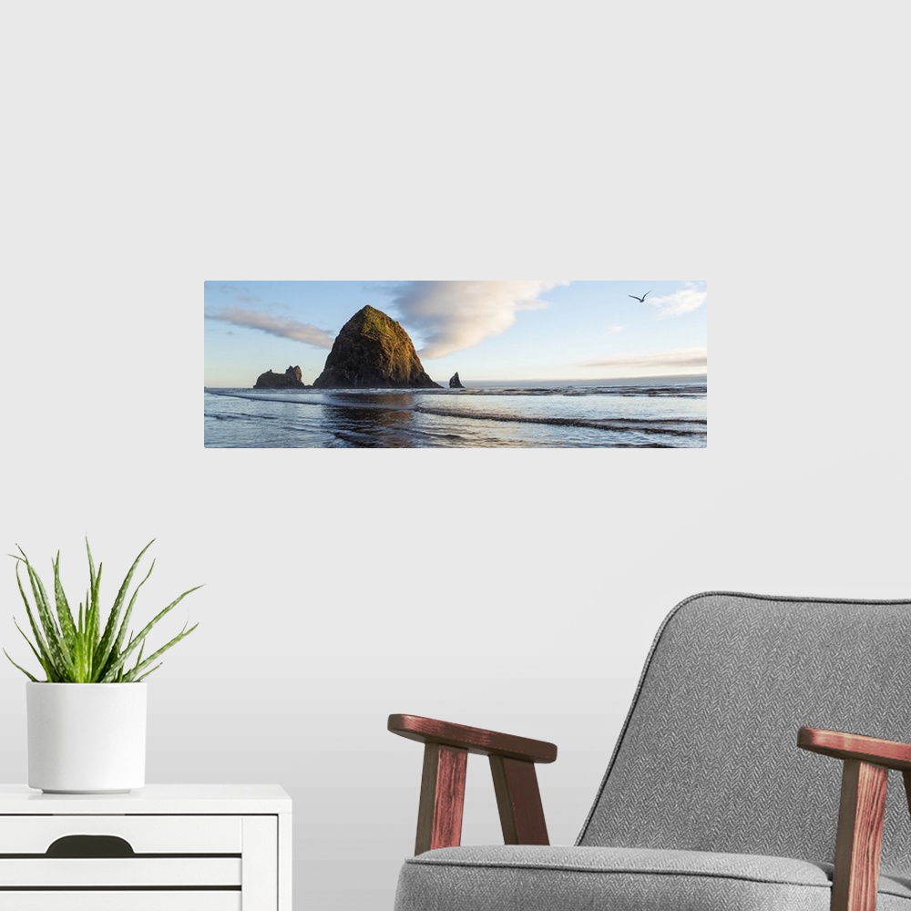 A modern room featuring Panoramic photograph of Haystack Rock with a bird flying in the sky at Cannon Beach.