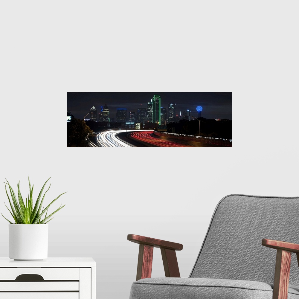 A modern room featuring Light trails fill the foreground with Dallas skyline in the background.