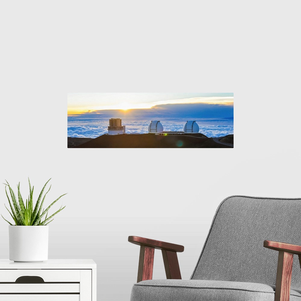 A modern room featuring Big Island Hawaii. The sun sets over the observatories on Mauna Kea.