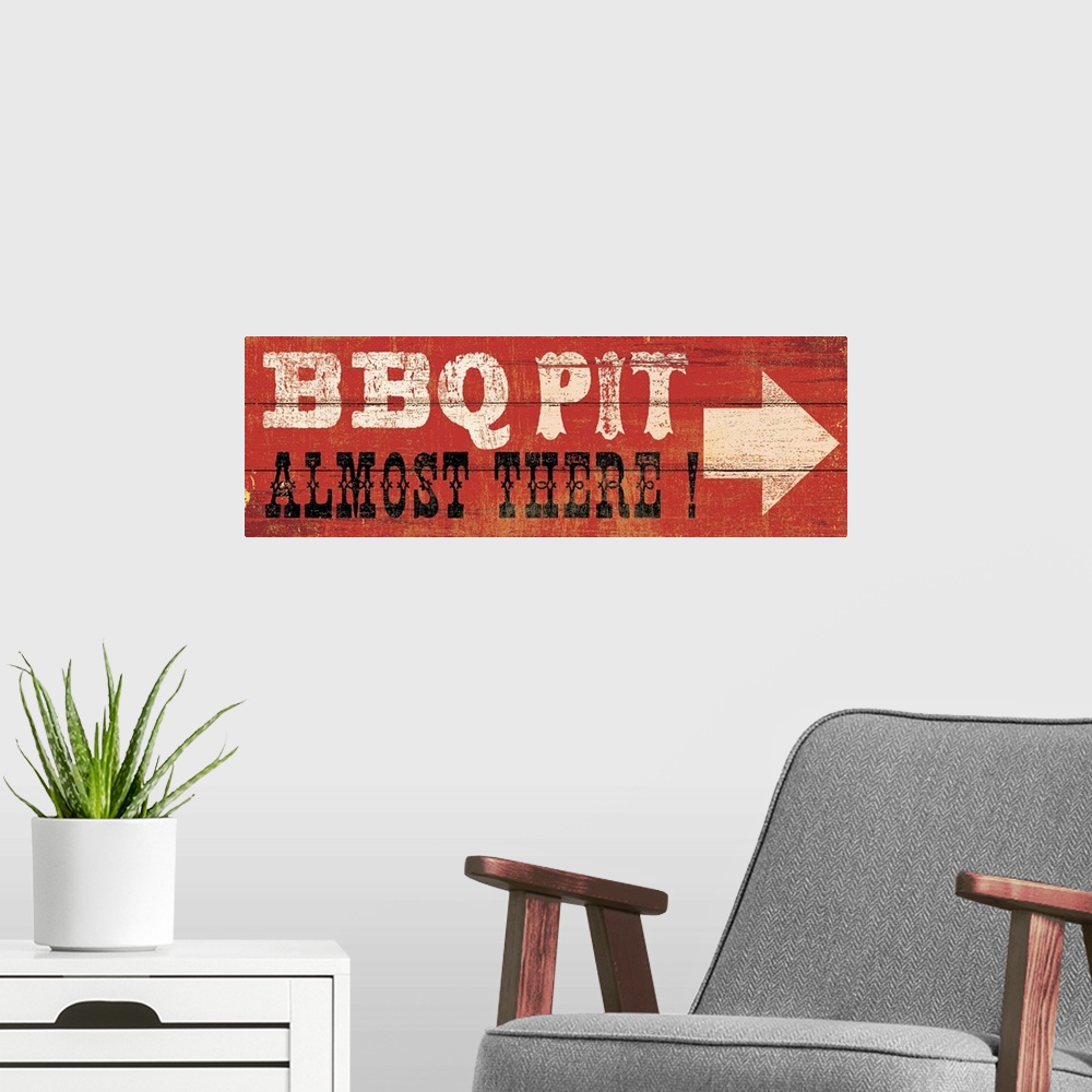 A modern room featuring This art piece resembles wood planks with an arrow and text painted saying BBQ Pit, Almost There.
